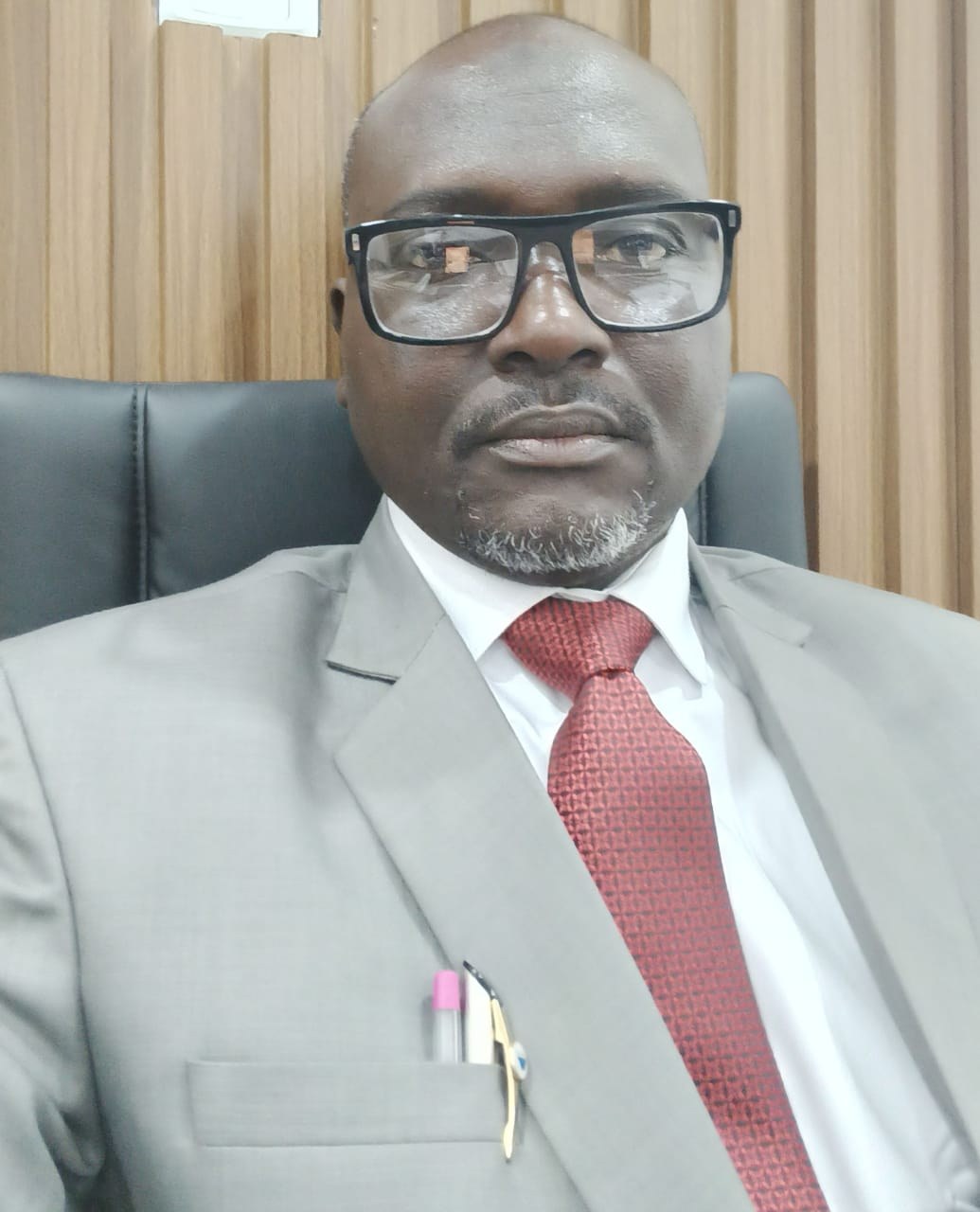 Ali Muhammad Lawan, CEO of Mamil Umrah Services, wearing a grey suit and red tie